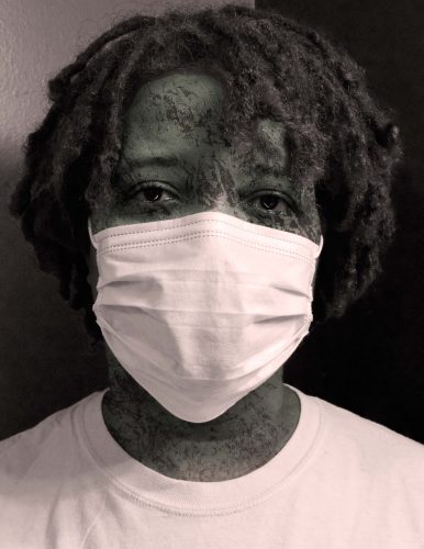 Person with dreadlocks wearing white face mask and white shirt, artistic black and white portrait photography
