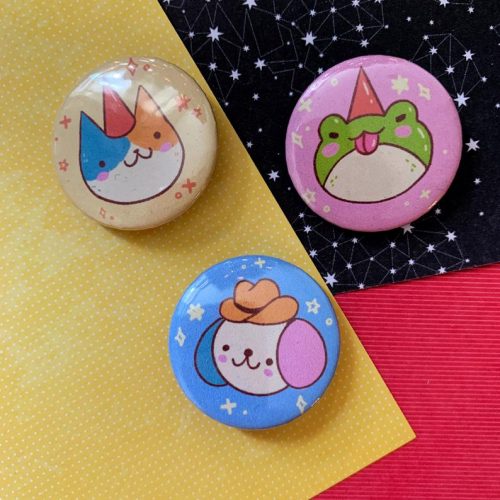 Cute kawaii character pins featuring unicorn, dragon, and cowboy designs on colorful star-patterned backgrounds