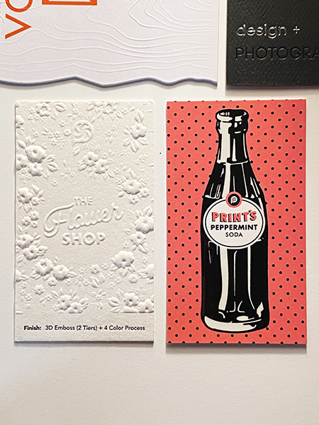 Business cards with embossed texture and vintage Coca-Cola style bottle design on polka dot background