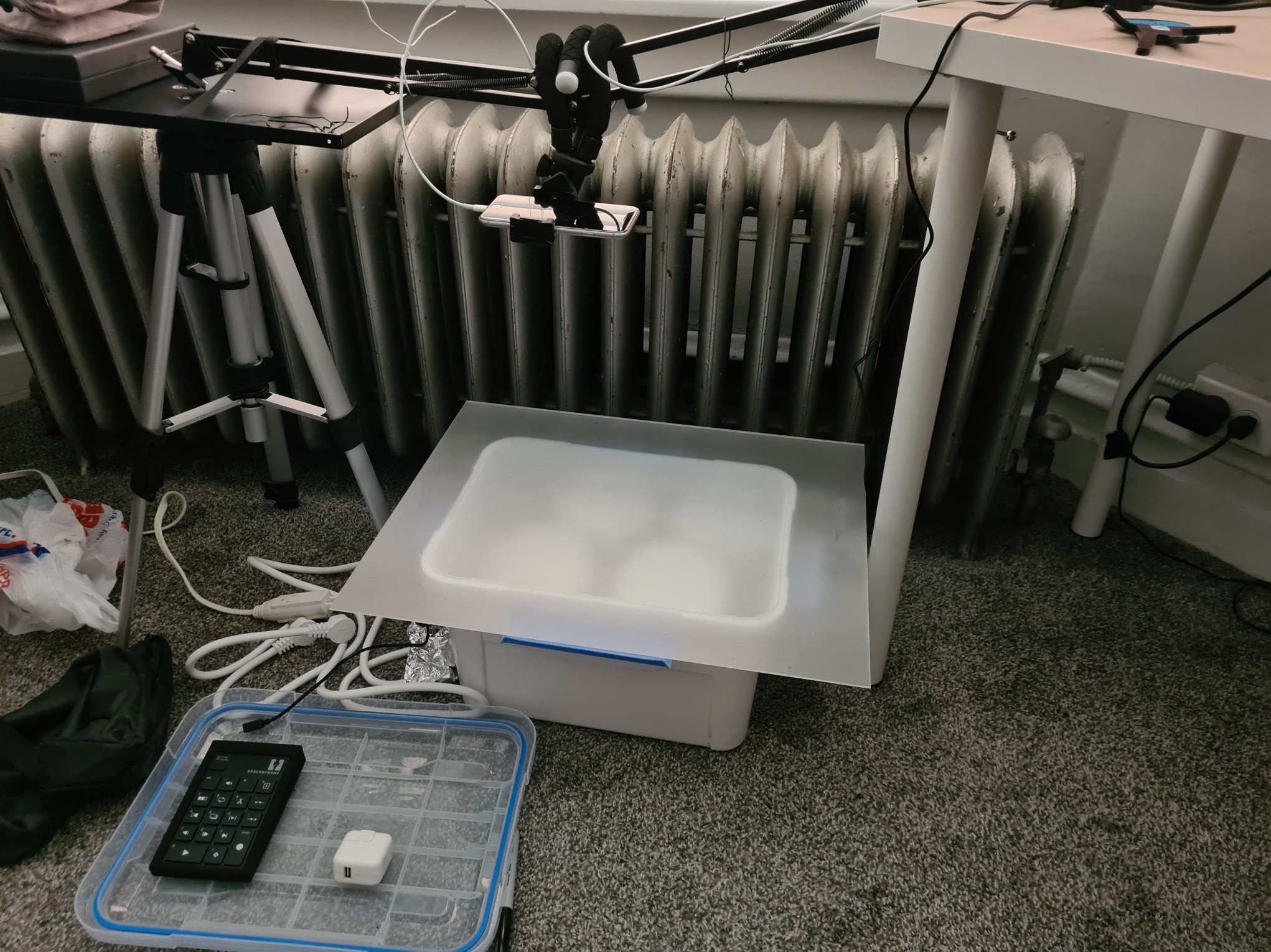 White 3D printer setup on desk with radiator, cables, and calculator on tray in workspace environment
